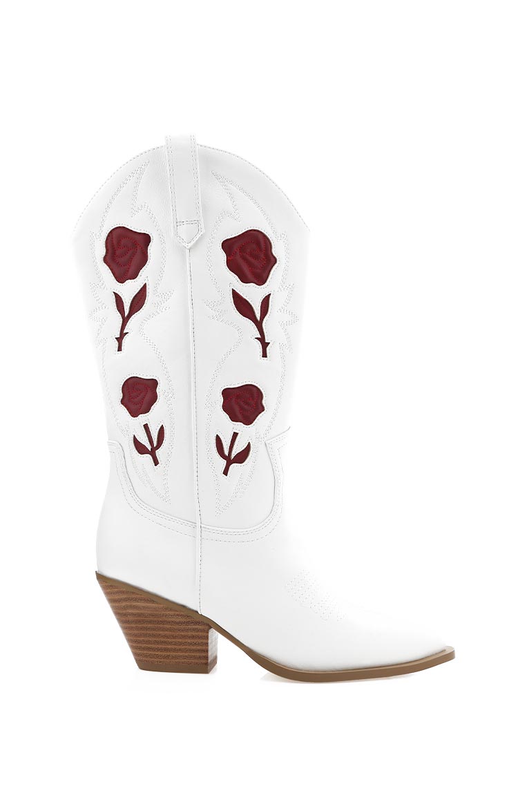 Side view of a white cowboy boot with red rose embroidery and a stacked wooden heel