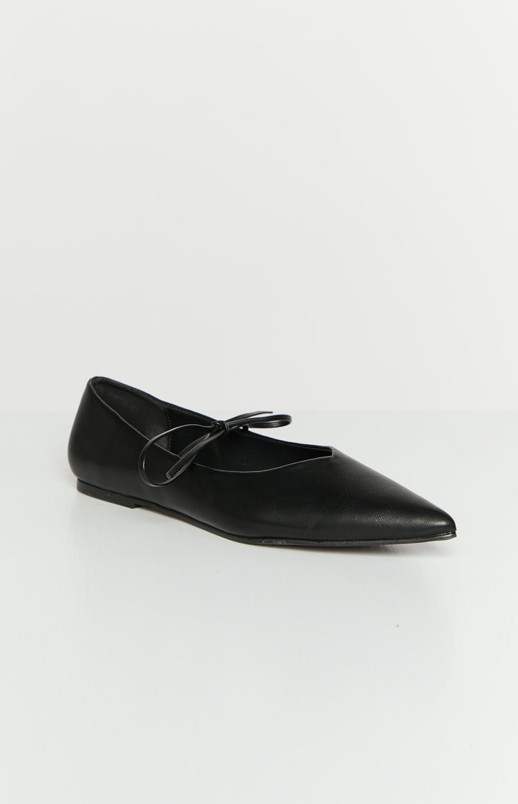 Black ballet flat with a pointed toe and a thin strap tied in a bow across the instep