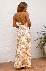 Rear view of a yellow floral satin maxi dress with criss-cross tie-back spaghetti straps and ruched detail