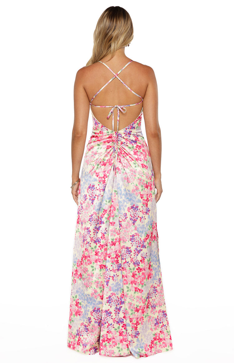 Back view of the multi floral satin maxi dress featuring a low scoop back, criss-cross straps, and ruched tie-back