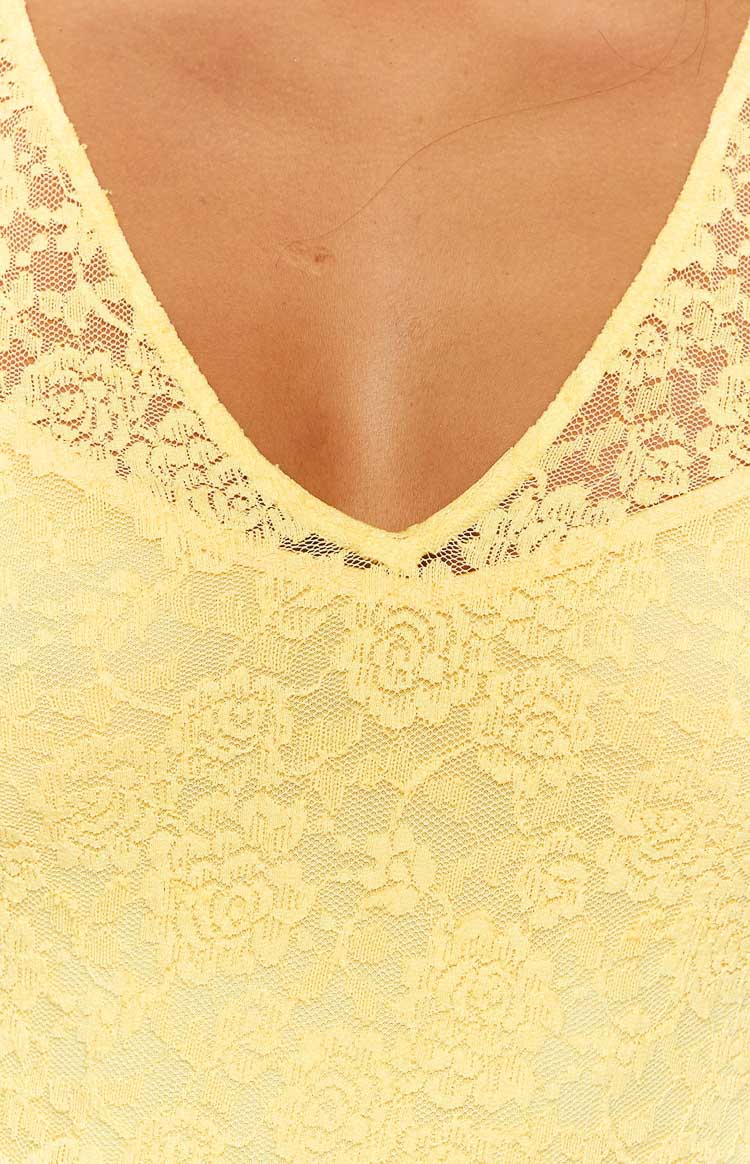 Close-up of the yellow floral lace fabric and V-neckline