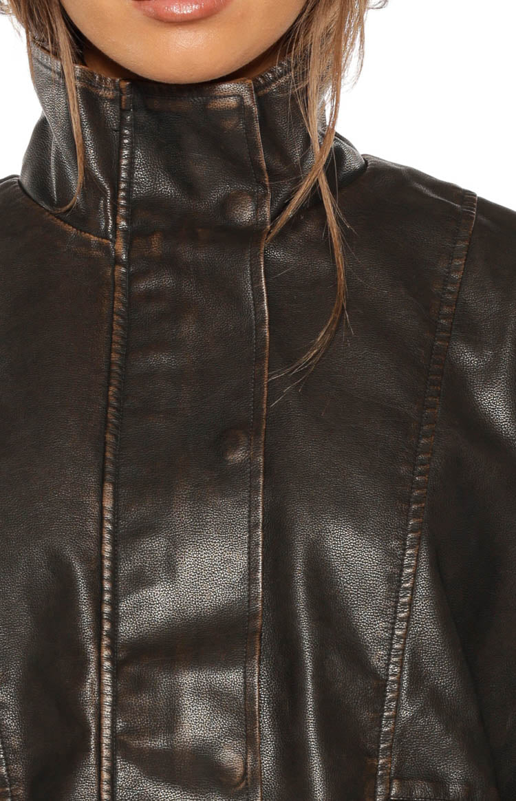 Close-up of the distressed brown PU leather funnel neck jacket with button closure and vertical seam details