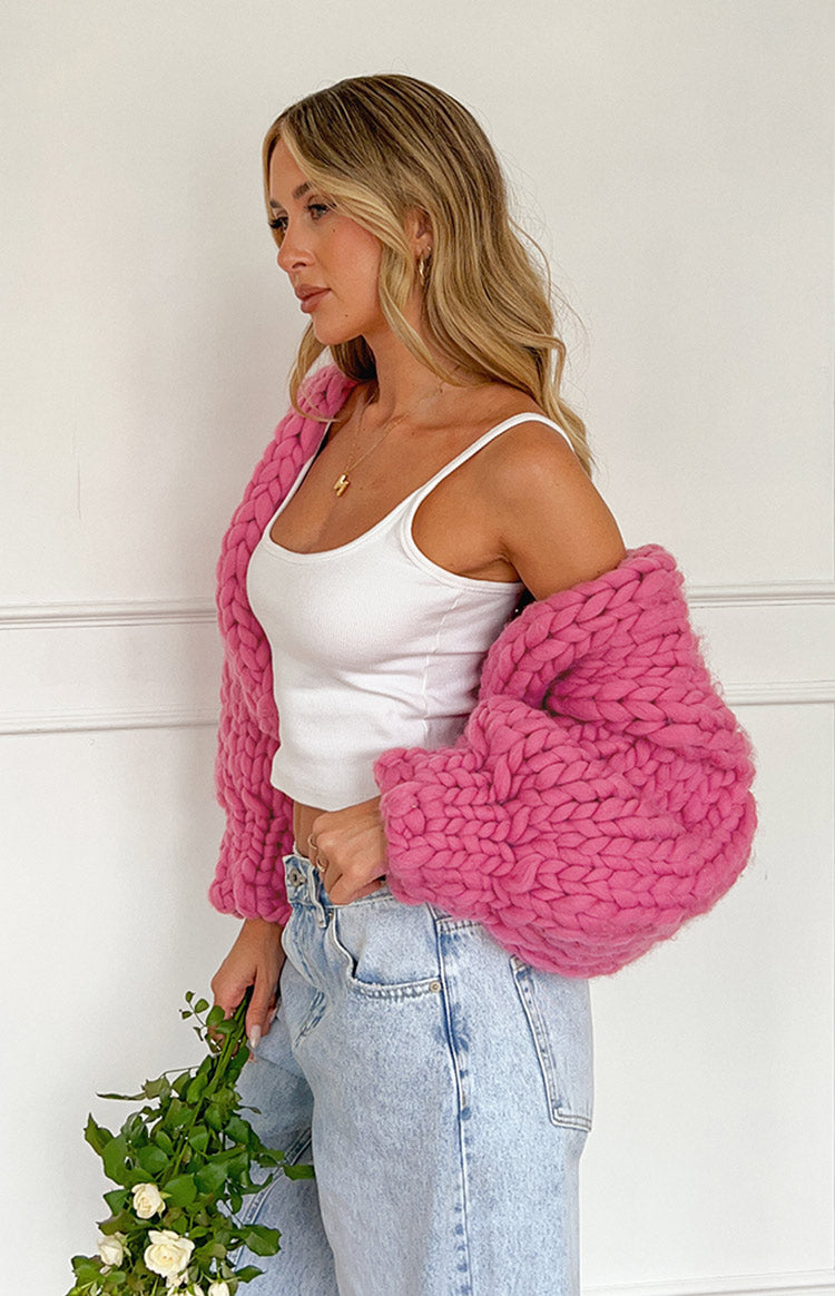 Side view of a pink chunky knit cardigan with oversized balloon sleeves