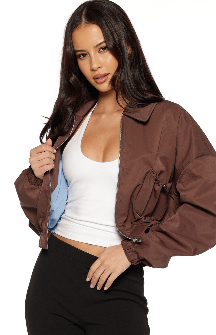 Close-up of the chocolate bomber jacket showing the light blue lining and side drawstring ruching detail