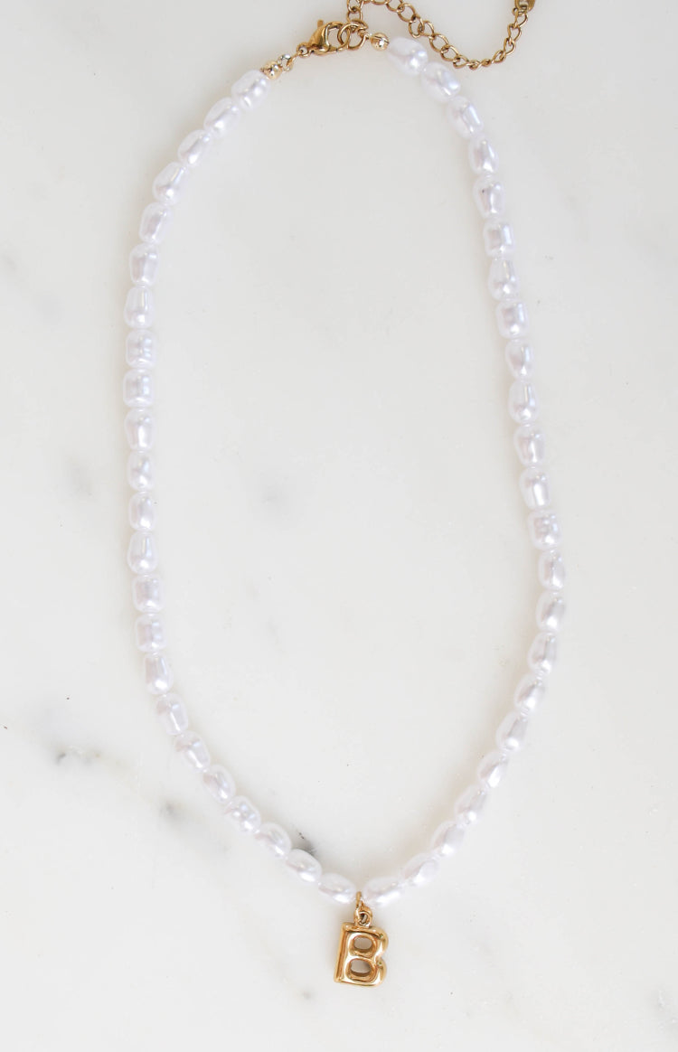 Full length view of a necklace featuring irregular white pearl beads and a gold initial B pendant