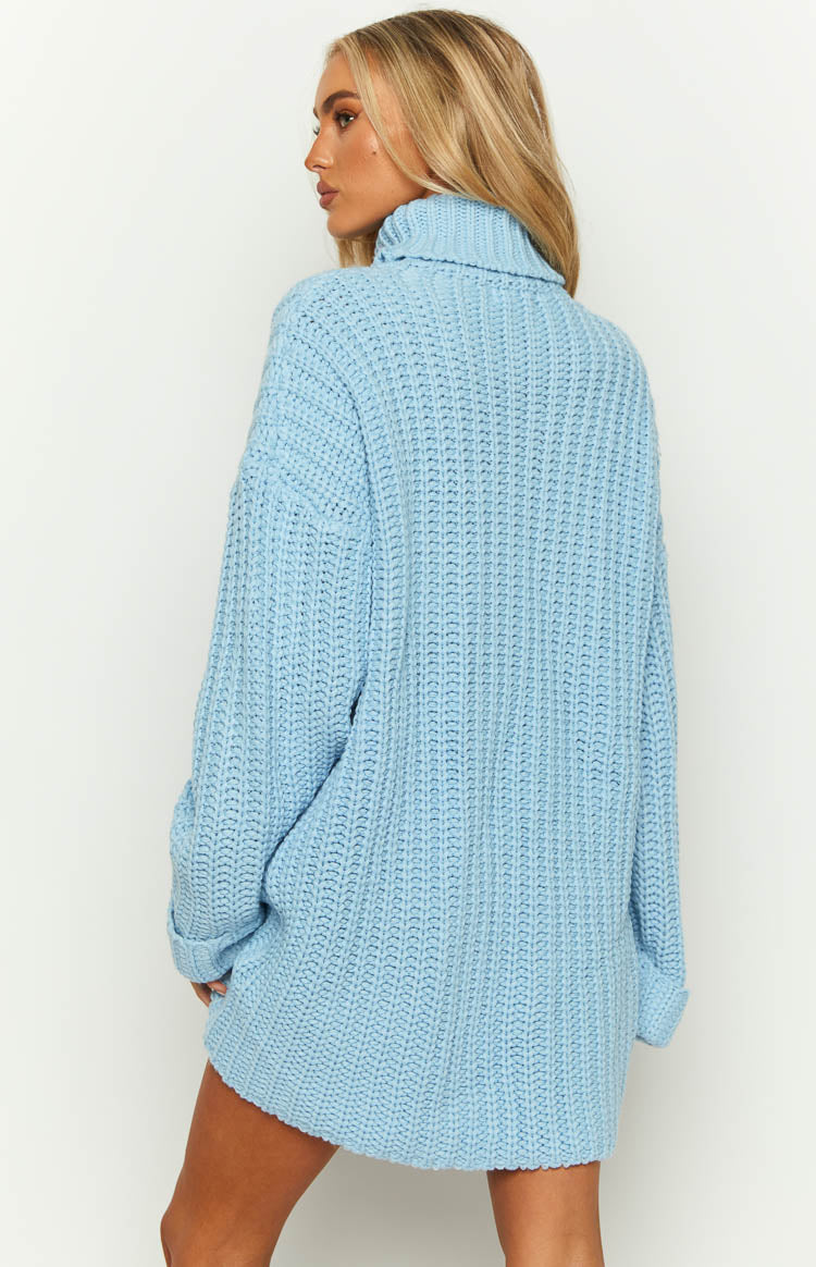 Rear side view of a light blue chunky knit turtleneck sweater dress with cuffed long sleeves