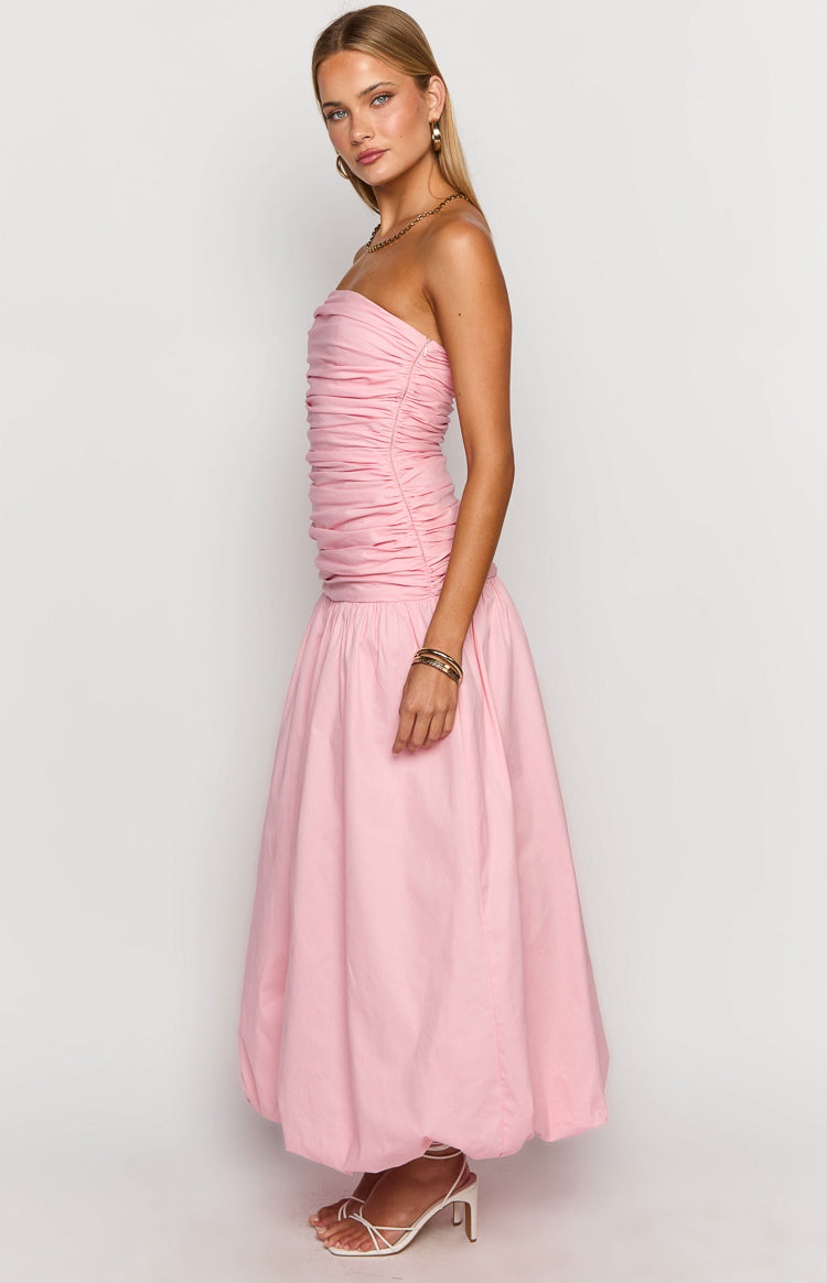 Side view of a pink strapless maxi dress with a ruched bodice and a voluminous bubble skirt