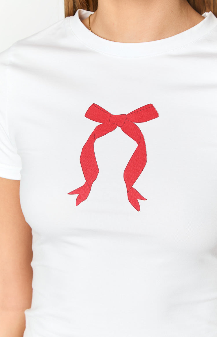 Close-up of the red bow graphic print on the front of a white baby tee