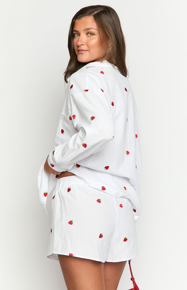 Side view of white boxer shorts with red strawberry embroidery and an elasticated waistband