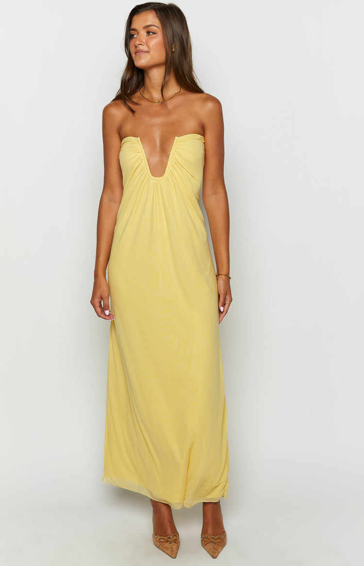 Front view of a yellow strapless maxi dress with a deep V-cutout neckline and sheer, flowy fabric