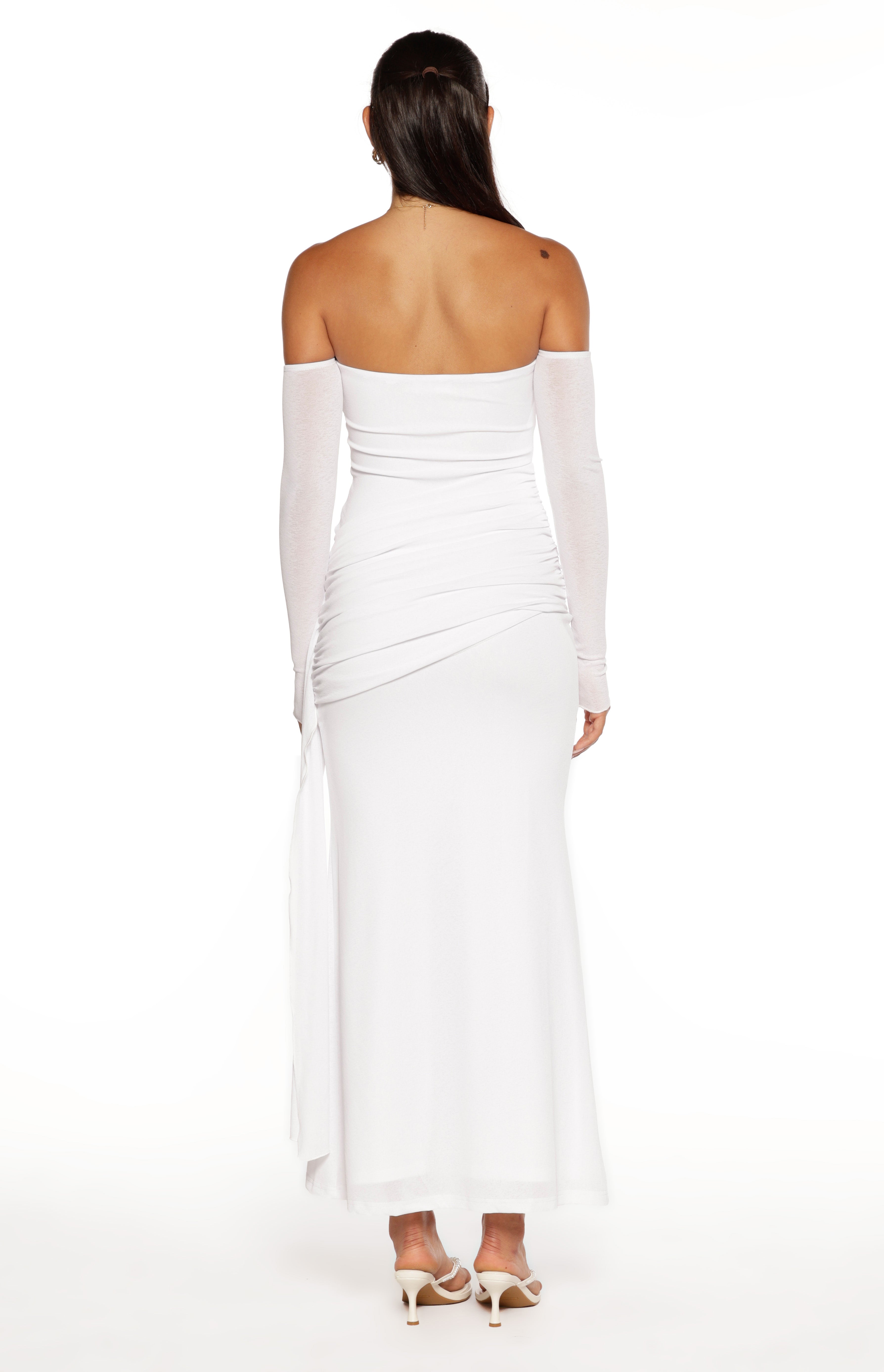 Rear view of a white strapless maxi dress with long sheer sleeves and ruched detailing on the back