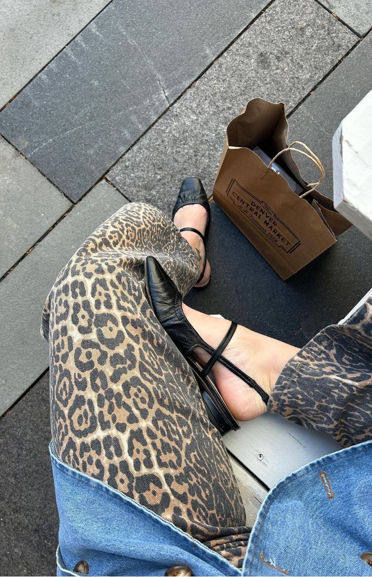 Close-up of the brown and black leopard print pattern on straight leg jeans