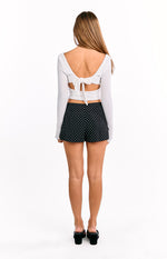 Back view of black shorts with small white polka dots and a relaxed, flowy fit