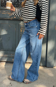 Mid wash blue low rise jeans with a wide leg cut and front button closure