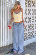 Full length view of light wash low rise wide leg denim jeans with front pockets and a button closure
