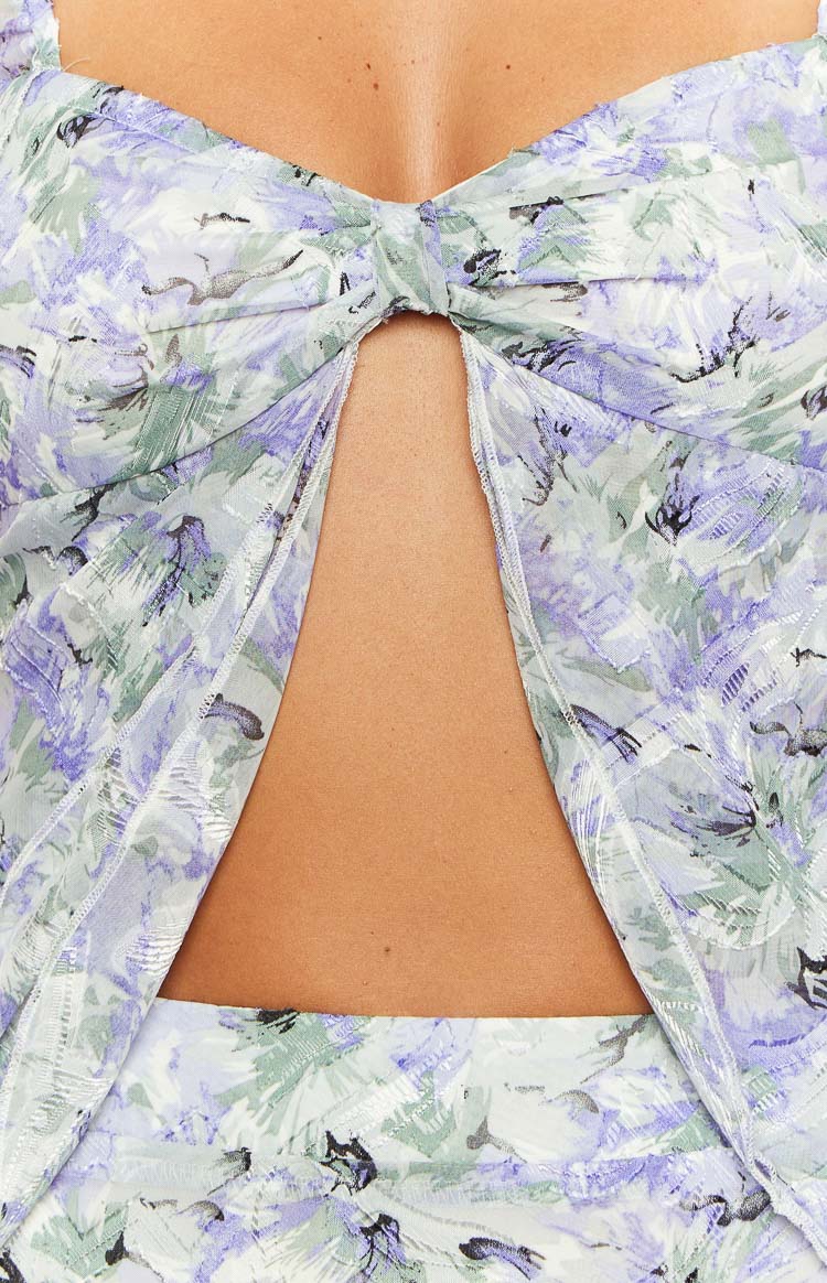 Close-up of the twisted knot detail at the bust of the purple floral print chiffon top with a cutout below