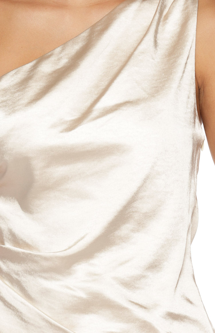 Close-up of the cream satin asymmetric top showing the fabric's luxurious sheen and soft drape