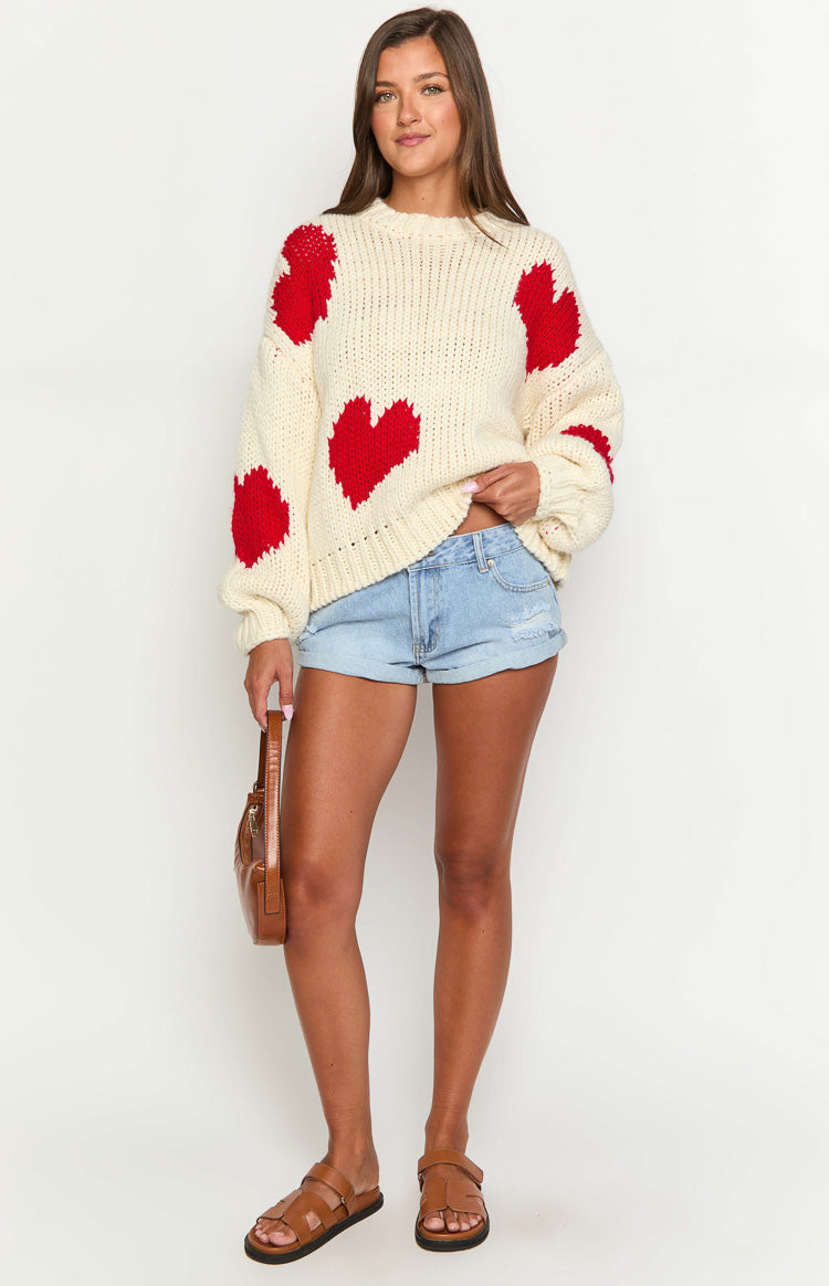 Oversized cream chunky knit sweater with red heart patterns on the body and long sleeves