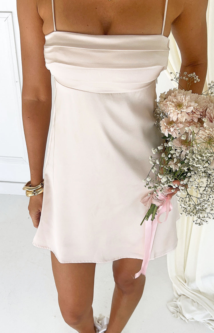 Close-up of the cream satin mini dress showing the draped bust detail and thin spaghetti straps