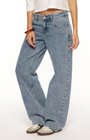Side view of mid wash denim baggy leg jeans with silver studs running down the outer seams