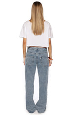 Rear view of mid wash denim low waist baggy leg jeans with back pockets and studded detail along the side seams