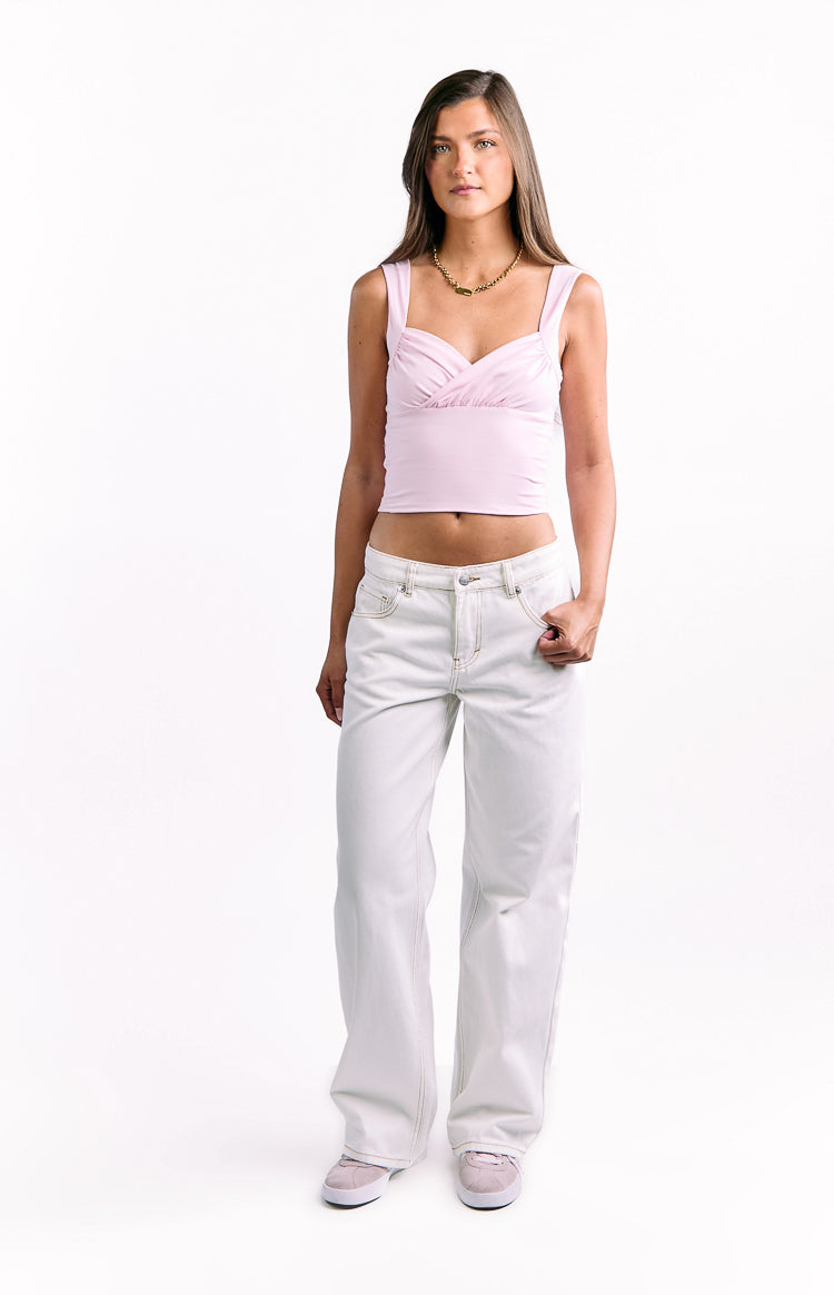 Front view of white low waist baggy leg jeans with light brown contrast stitching and front pockets