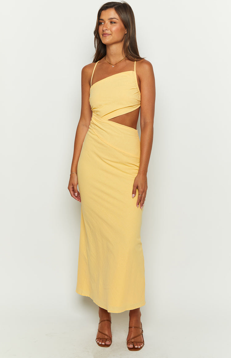 Yellow maxi dress with an asymmetrical neckline, side waist cutout, and ruched detailing