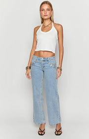 Front view of light wash low rise denim jeans with silver sequin detail on the front pockets and a wide leg