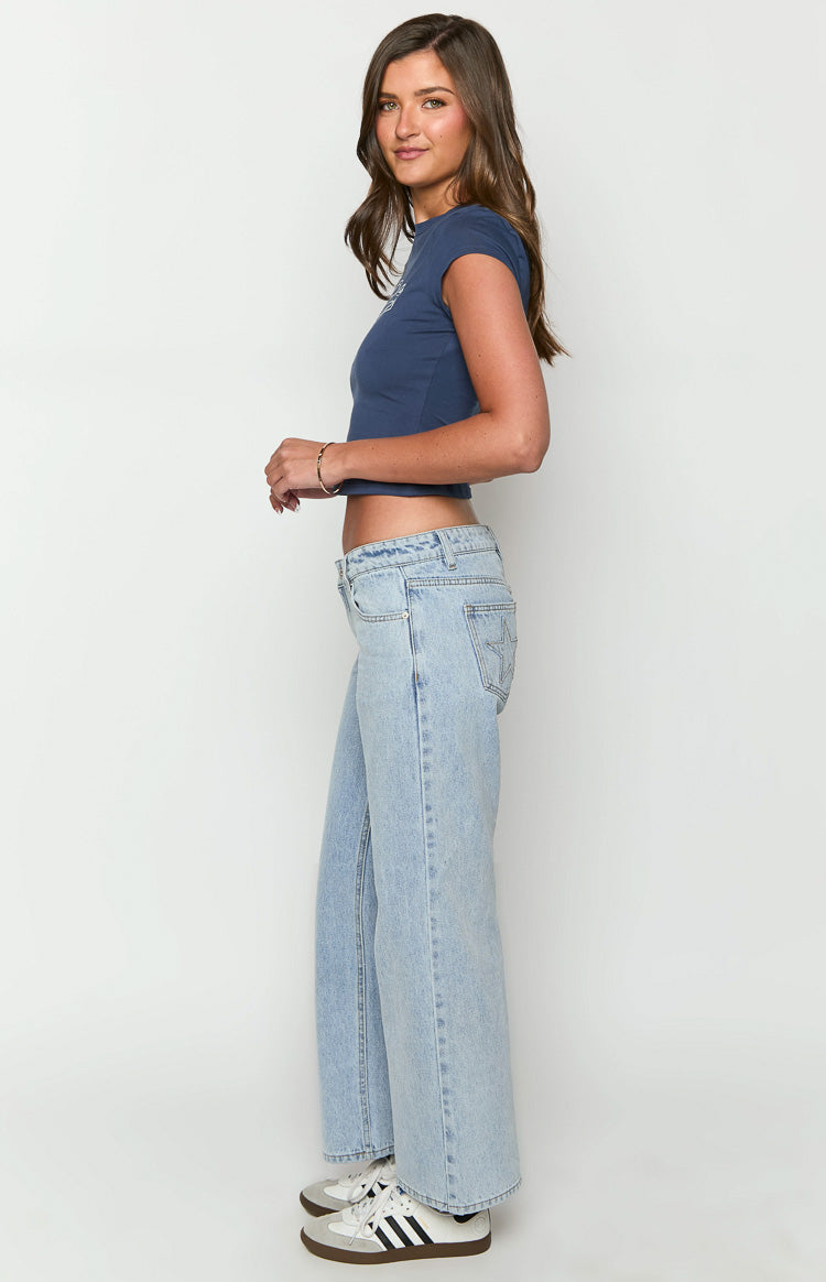 Side view of light wash low rise denim jeans with a wide leg and star pocket detail