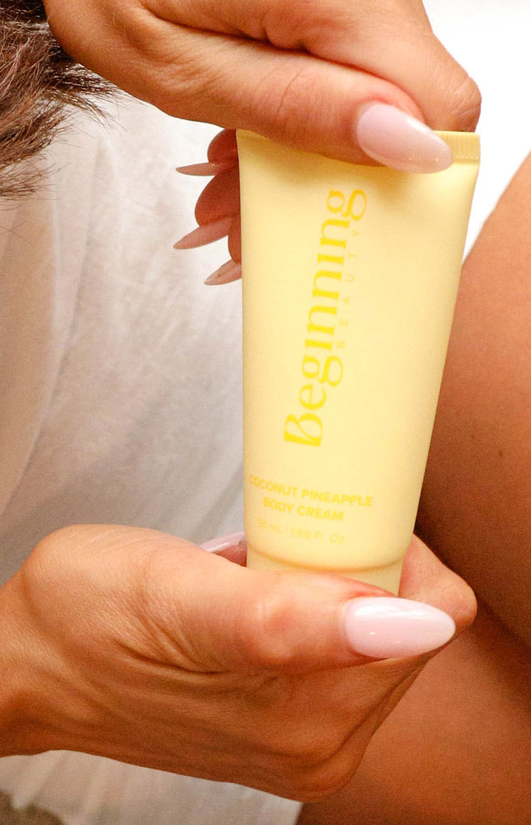 Close-up of a soft yellow squeeze tube of body cream with product details printed on it