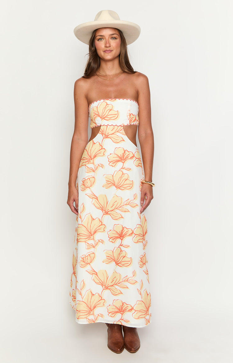 White strapless maxi dress with orange floral print, featuring a scalloped bustline and side waist cutouts