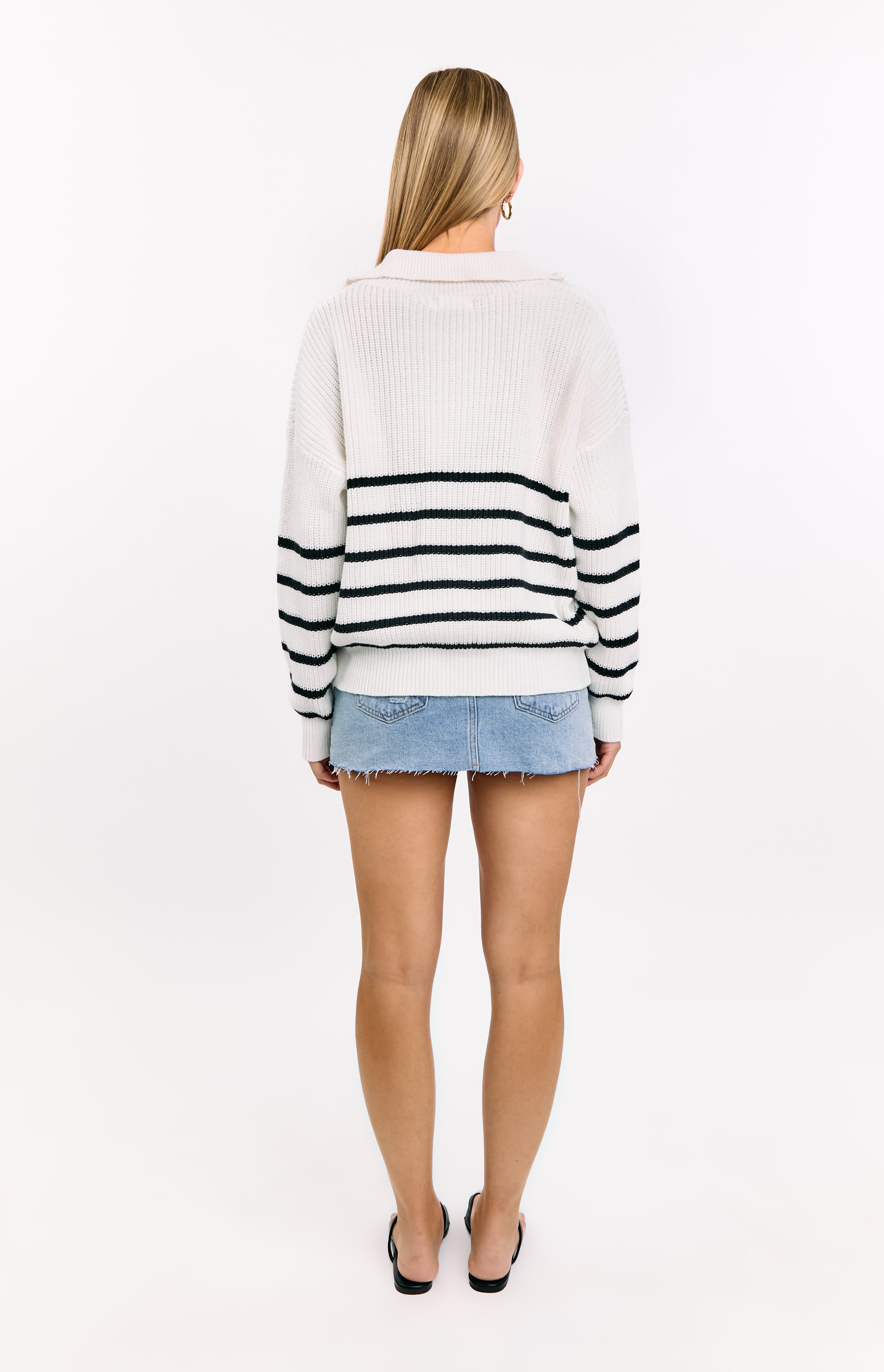 Rear view of a cream knit jumper with black horizontal stripes across the back and sleeves