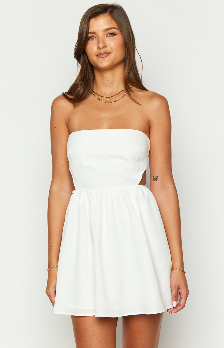 Front view of a white strapless mini dress with side cutouts and a gathered waist