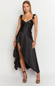 Black satin maxi dress with ruffled straps, V-neck, and an asymmetrical high-low hem with a thigh-high slit