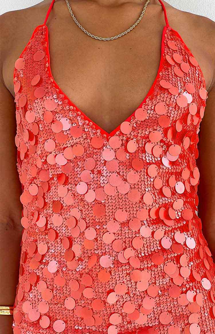 Close-up of the orange sequin mini dress showing the V-neckline and varying sequin sizes