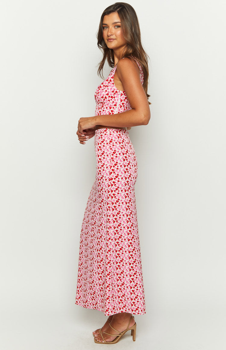 Side view of a pink and red speckled maxi skirt, fitted through the hips and flowing to the hem