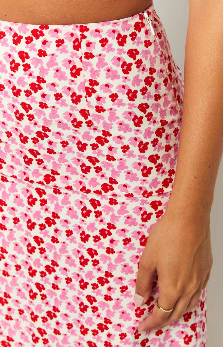 Close-up of the white maxi skirt with a pink and red speckled floral pattern and a hidden side zipper