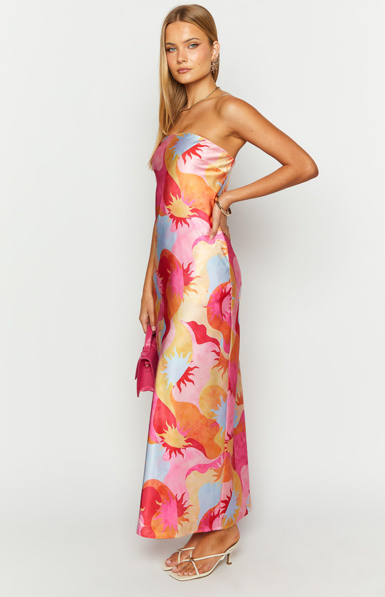 Side view of a strapless pink and orange satin maxi dress with a vibrant sun print and a relaxed silhouette