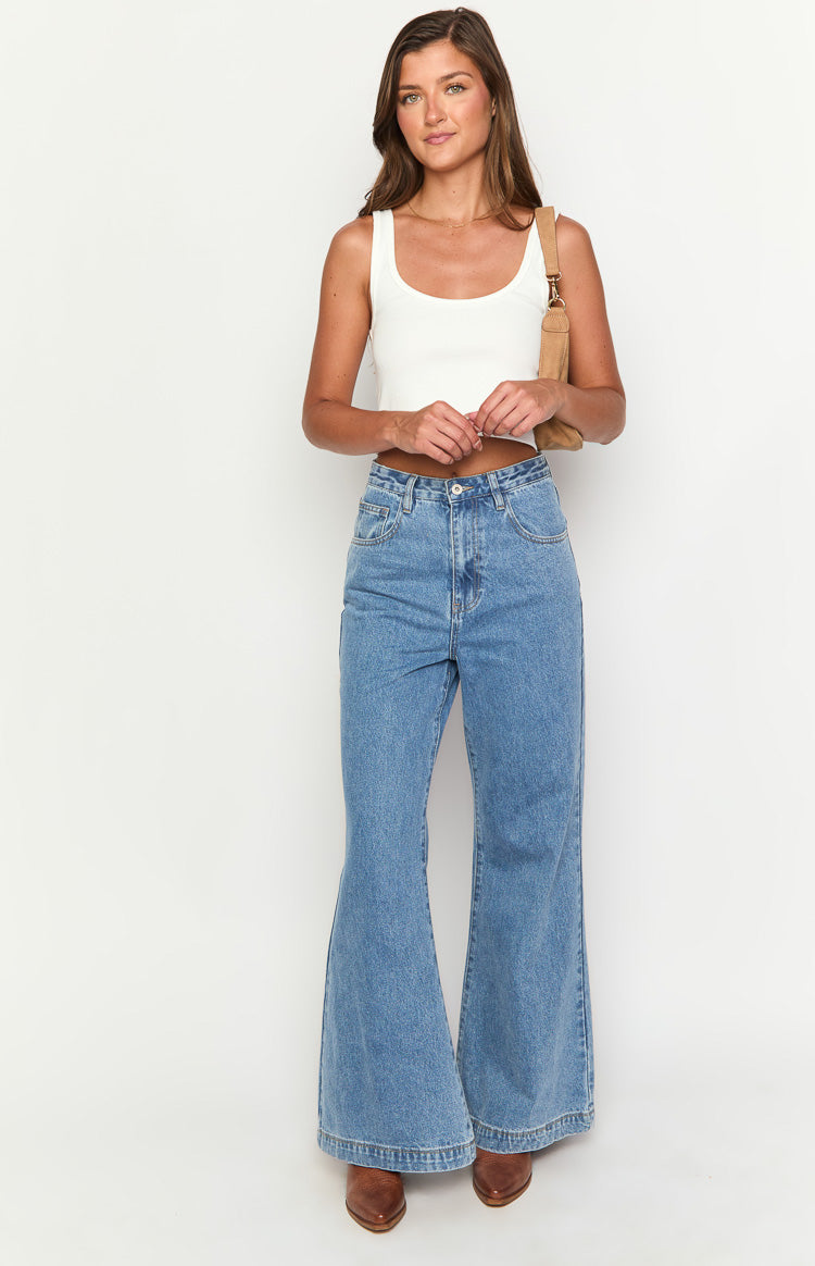 Front view of mid wash denim flare jeans with a high waist and wide leg
