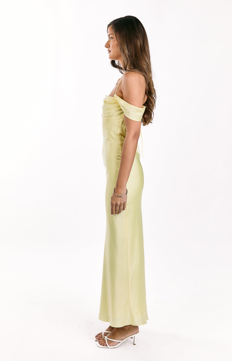 Side view of a light yellow off-shoulder maxi dress with spaghetti straps and a fitted silhouette