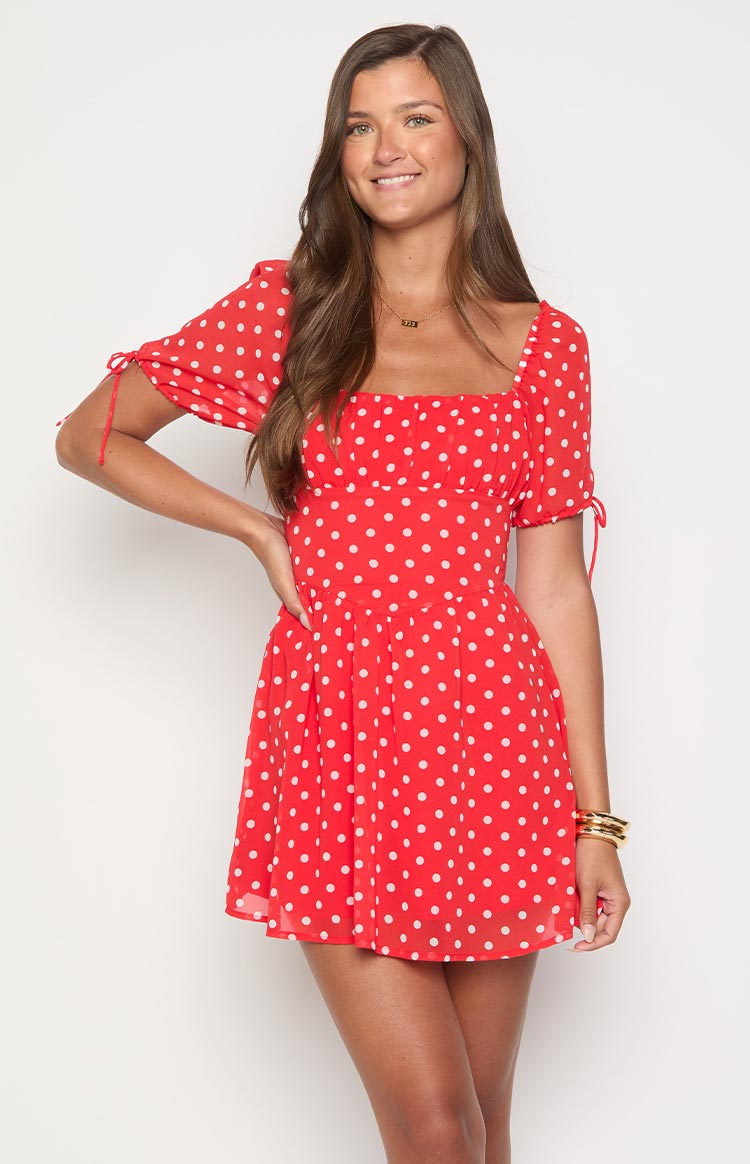 Red polka dot mini dress with a square neckline, gathered bust, and tie-detail puff sleeves