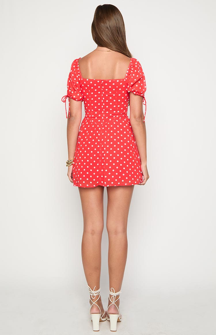 Rear view of a red polka dot mini dress with a square back and short puff sleeves with ties