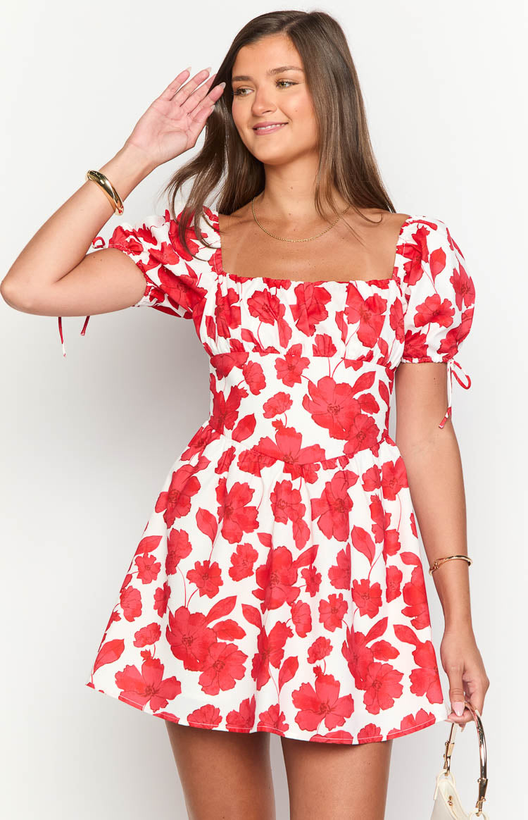 Front view of a white mini dress with red anemone floral print, square neckline, and puff sleeves with tie details