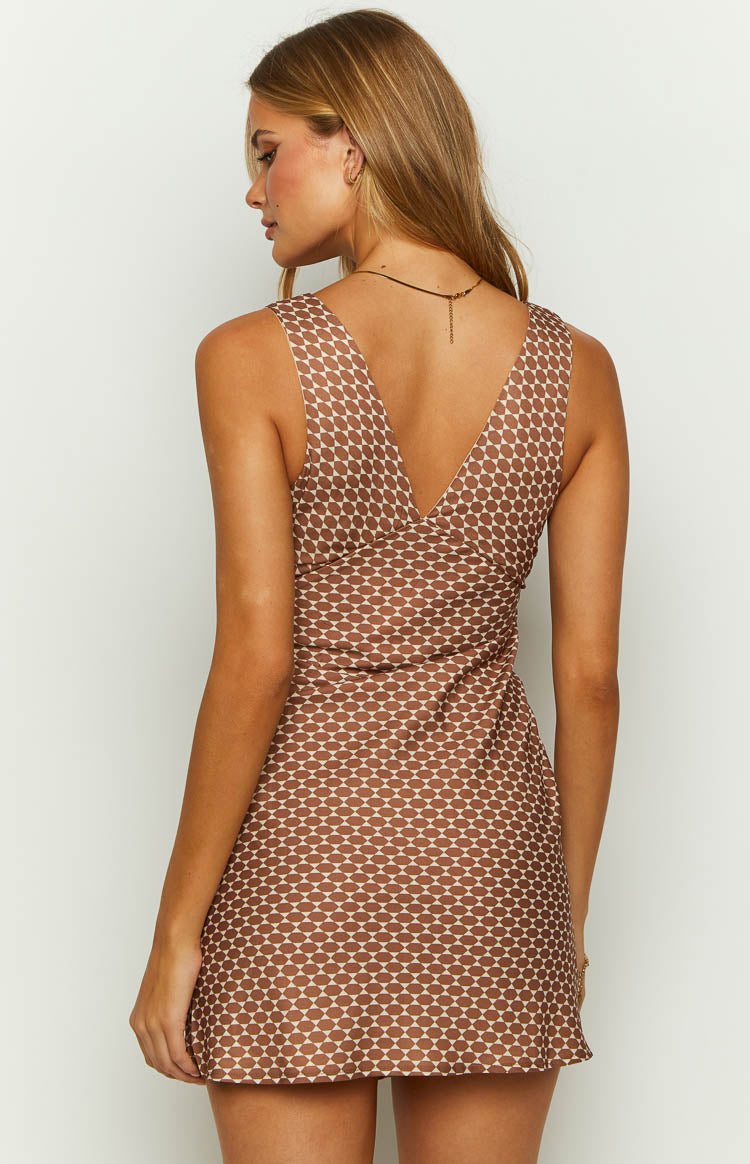Back view of a chocolate brown mini dress with a deep V-neckline and an all-over white geometric circle pattern