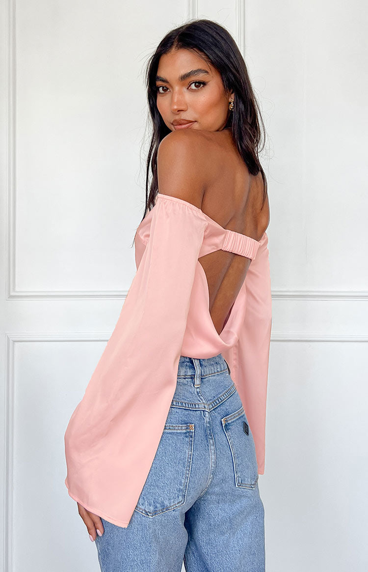 Rear view of a pink satin off-shoulder long sleeve top with an open back and ruched elastic strap