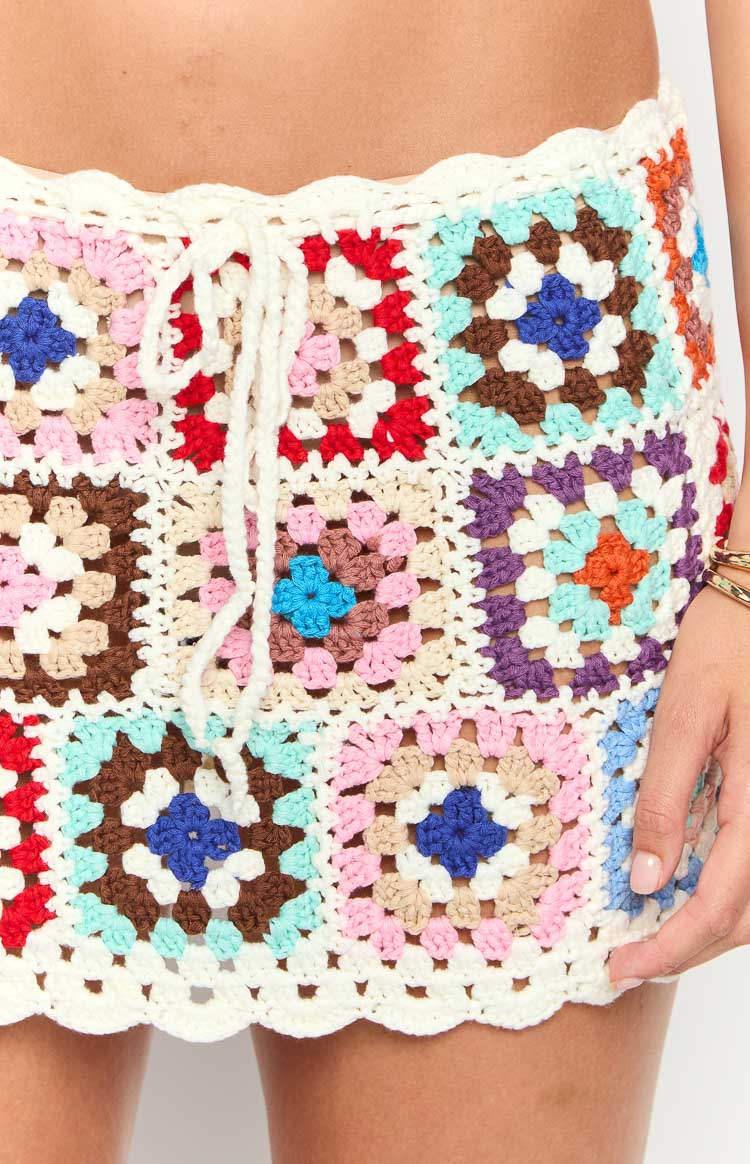 Close-up of the multi-coloured granny square crochet mini skirt, showing drawstring waist and scalloped hem
