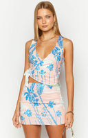 Front view of a fitted peach white and blue palm print mini skirt with a tropical design