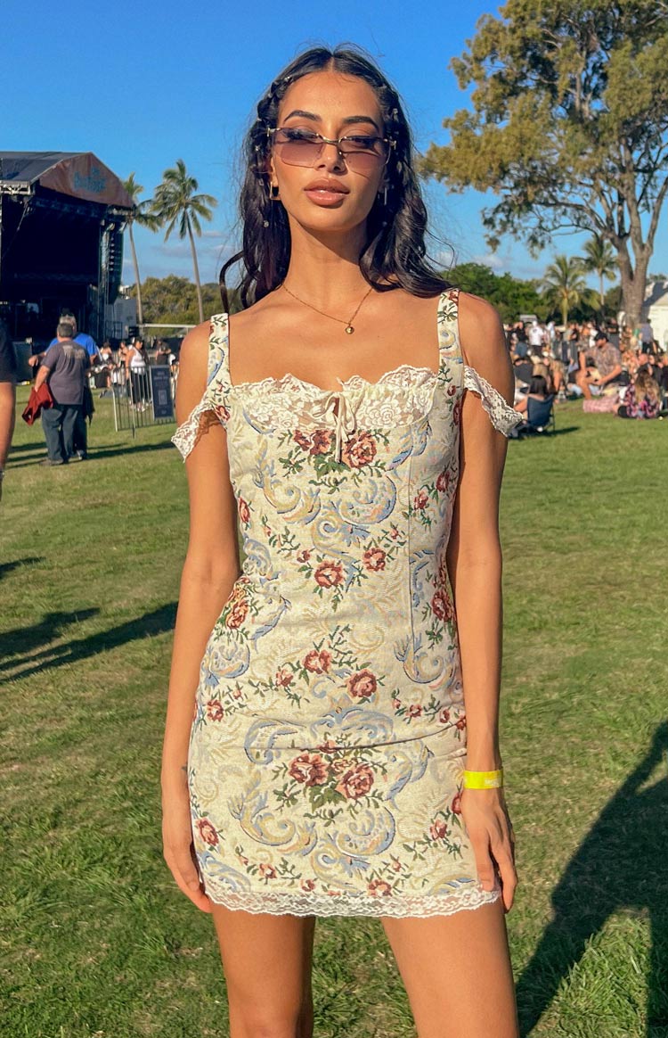 Beige tapestry mini dress with a square neckline, white lace trim, and off-shoulder lace straps