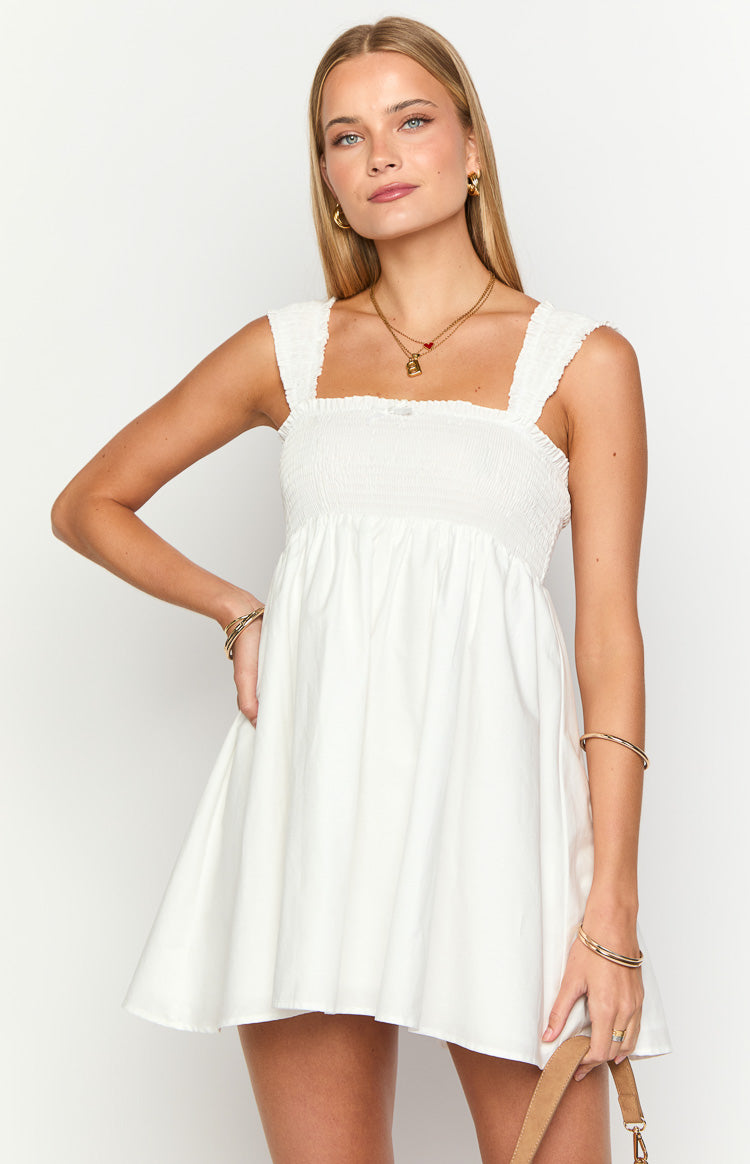 White mini dress with a smocked bodice, square neckline, and textured cap sleeves