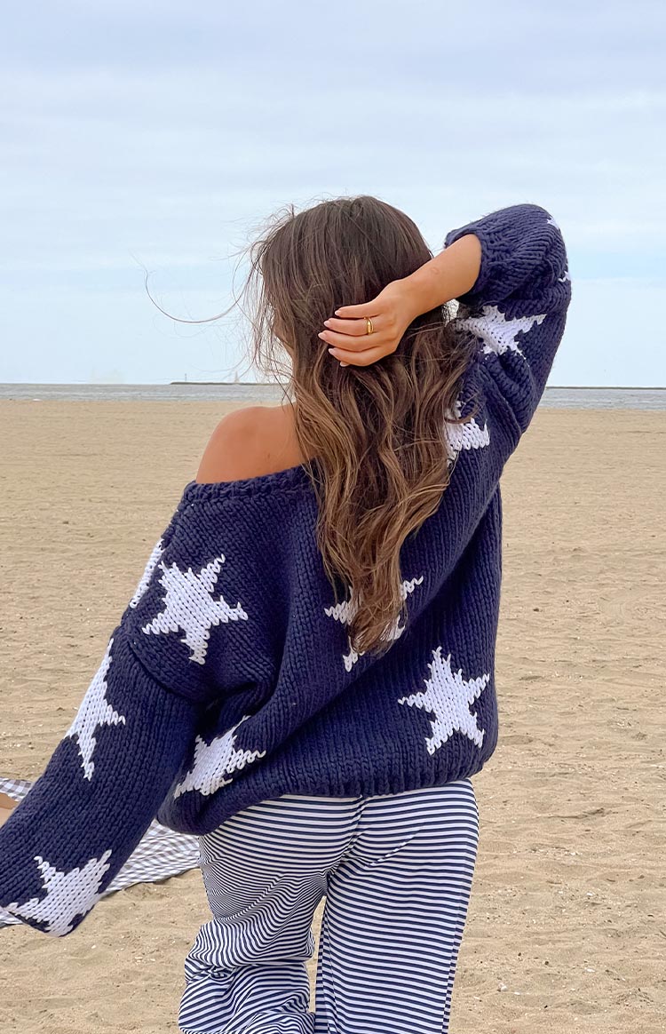Navy chunky knit sweater with white stars, showing the back and off-shoulder detail